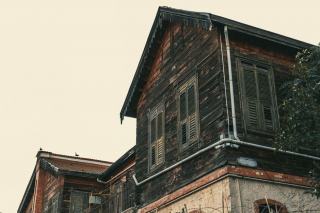 Façade d'un immeuble ancien aux fenêtres en bois, typique des logements mal isolés